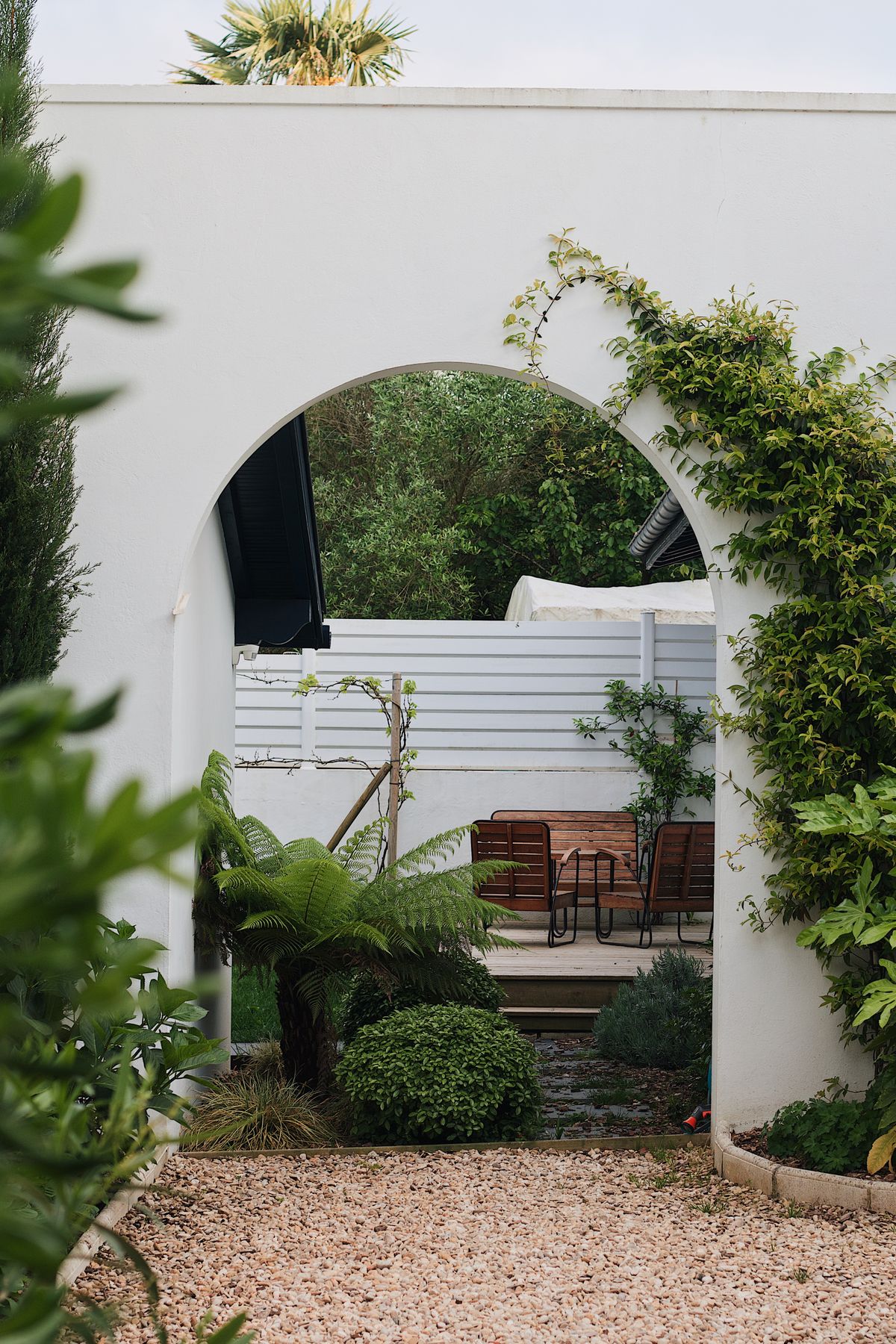 Gartenbereich mit Bogen und bepflanzten Beeten