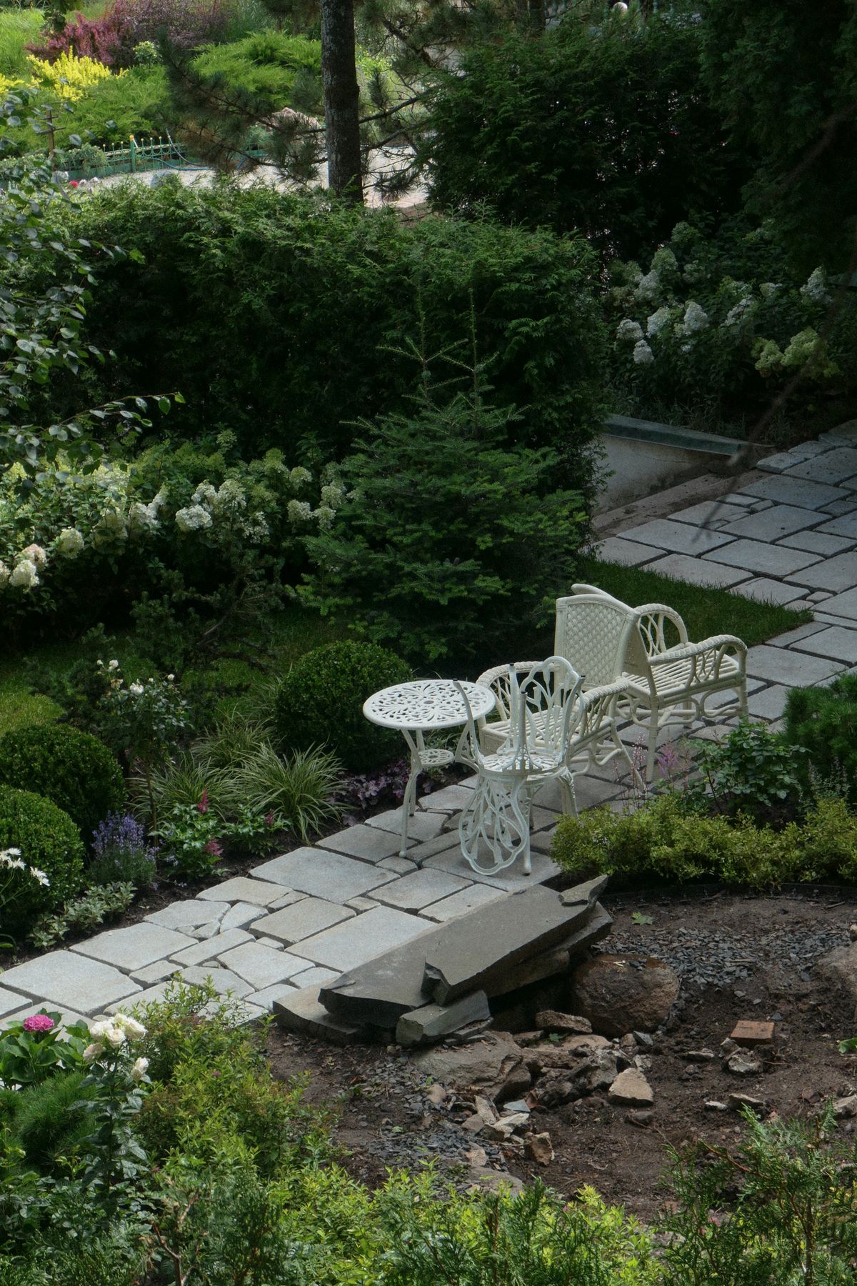 Gartenmöbel auf gepflastertem Weg
